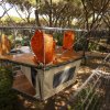 Casetta sospesa su struttura di rete in un bosco.