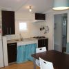 Cucina moderna con mobile nero, tavolo e sedie bianche.