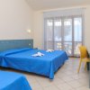 Camera d'hotel con letto matrimoniale e lenzuola blu.