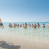 Persone in acqua vicino alla riva su una spiaggia soleggiata.