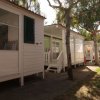 Bungalow bianchi tra gli alberi in un campeggio.