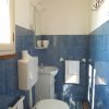 Bagno con piastrelle blu e sanitari bianchi.