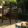 Parco giochi con scivoli e attrezzature su sabbia.