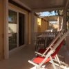 Veranda con sedie a sdraio rosse e tavolo bianco.