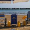 Sedia a rotelle da spiaggia sulla sabbia davanti al mare.