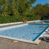 Piscine all'aperto con lettini bianchi e persone che si divertono sotto il sole.