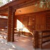 Una veranda in legno con due sedie e un tavolo, accanto a una porta di legno.