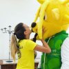 Persona abbraccia e bacia un costume da mascotte giallo.