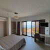 Camera d'albergo moderna con letto matrimoniale, scrivania e balcone vista mare.