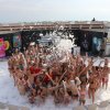 Una festa in piscina piena di schiuma con molte persone in costume.