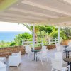 Terrazza con sedie bianche e vista sul mare.