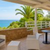 Terrazza con vista mare, arredamento bianco.