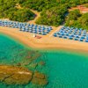 Spiaggia con ombrelloni blu e mare cristallino.