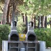 Due barbecue in muratura con alberi sullo sfondo.