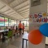 Pranzo per bambini in una sala con decorazioni colorate e animatori.