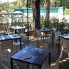 Tavoli apparecchiati all'aperto con vista su una piscina e alberi.