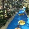 Persone su ciambelle gialle in un fiume lento circondato da alberi.