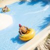 Persone su gonfiabili su uno scivolo d'acqua.