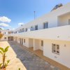 Complesso residenziale bianco con cortile e piante.