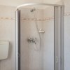 Bagno con doccia e piastrelle chiare.