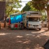 Camper parcheggiato tra gli alberi in un'area campeggio.