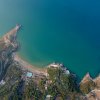 Vista aerea di una baia con mare blu e spiagge.