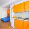 Cucina con letti a castello e armadio arancione.