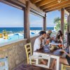 Persone sedute a un tavolo in un ristorante vista mare.