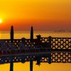 Tramonto sul mare con sedie a sdraio in silhouette.