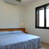 Camera da letto con letto matrimoniale, coperte azzurre, finestra con luce naturale.