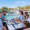 Famiglia a tavola vicino a una piscina, godendo di una colazione all'aperto.