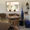 Una sala con tavoli in legno e sedie in vimini, decorata con vasi blu.