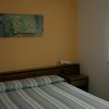 Una camera con un letto matrimoniale, parete gialla e quadro floreale.