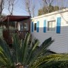 Casa mobile bianca con persiane blu e veranda.