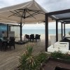 Ristorante sulla spiaggia con tavoli sotto grandi ombrelloni.
