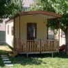 Casa mobile con veranda e sedie su prato.