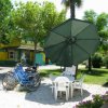 Tavolo con ombrellone e biciclette in un giardino.
