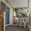 Veranda esterna con tavolo e sedie bianche di plastica.
