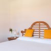 Camera da letto con letto matrimoniale, testiera in legno e cuscini gialli.