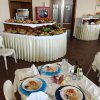 Sala da pranzo con tavolo preparato, buffet sullo sfondo.