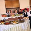Gruppo in piedi dietro a un buffet di pietanze.