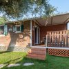 Una casa mobile in legno con veranda e gradini in un giardino verde.
