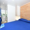 Una camera con letto matrimoniale e singolo, copriletti blu e parete in legno.