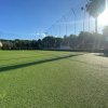 Campo sportivo con erba sintetica e recinzione alta.