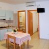 Monolocale con cucina, tavolo, letto e porta aperta sul bagno.