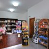 Interno di un negozio con scaffali di prodotti e una persona al bancone.