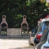 Due barbecue in mattoni vicino a un'auto parcheggiata.