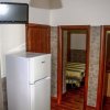 Interno con frigorifero, TV a muro e porte che conducono alle camere.