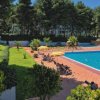Piscina con sdraio e ombrelloni arancioni.