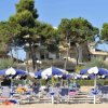 Spiaggia con ombrelloni blu e bianchi e sdraio.